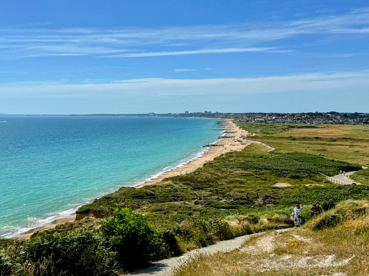 A turquoise bay and winding path along the southern English coastline