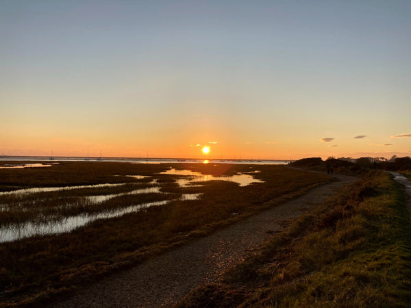 The sun setting over tidal creeks and saltmarsh