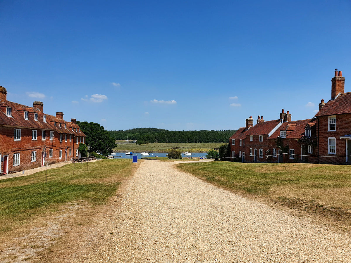 Traditional brick cottages beside a village green and river