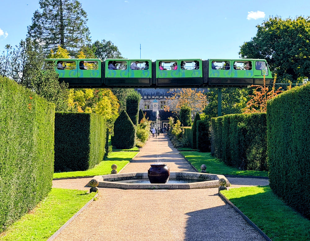A miniature railway crossing above a formal garden